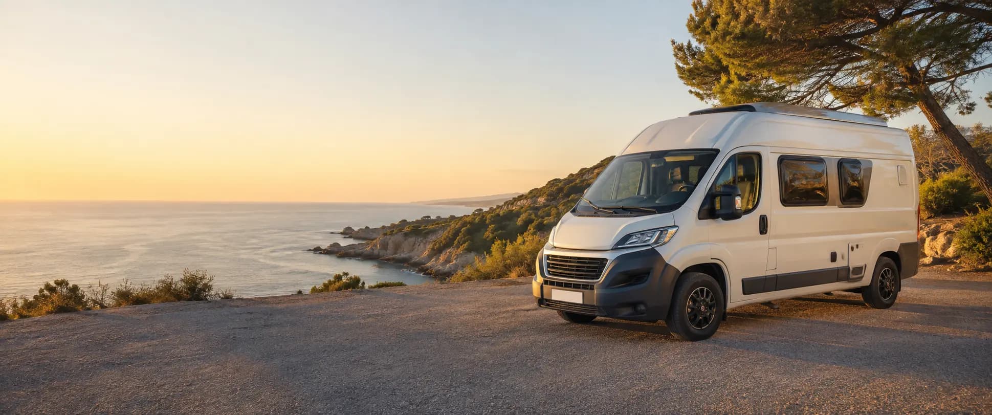 Autocaravana aparcada frente a la costa al atardecer